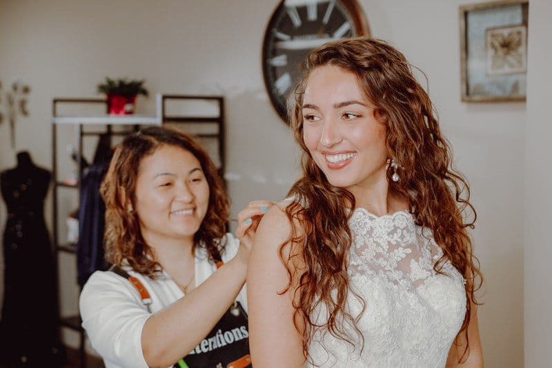 Bridal gown restyling in Tulsa — tailor adjusting lace on an heirloom wedding gown